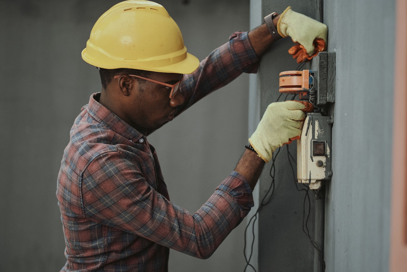 An electrician wiring a new outlet box during a residential electrical upgrade.